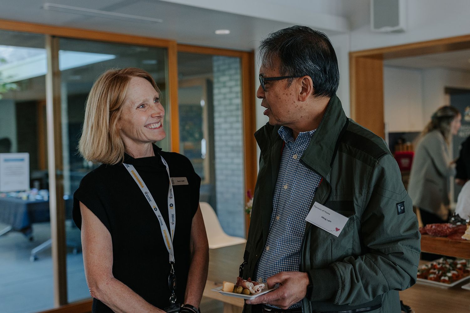 People networking and having conversations at an indoor business event.