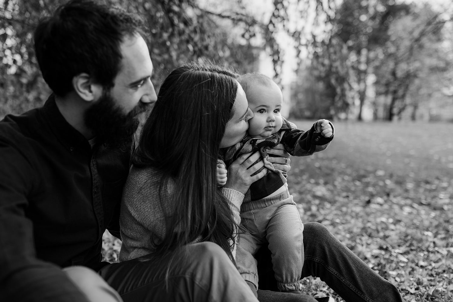 Black and white outdoor family portrait session showing intimate candid moments in nature.