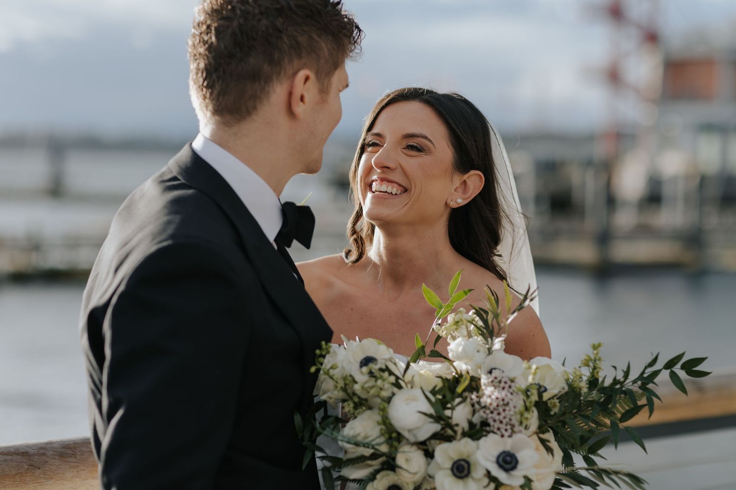 Romantic waterfront wedding portraits showing tender moments between newlyweds.