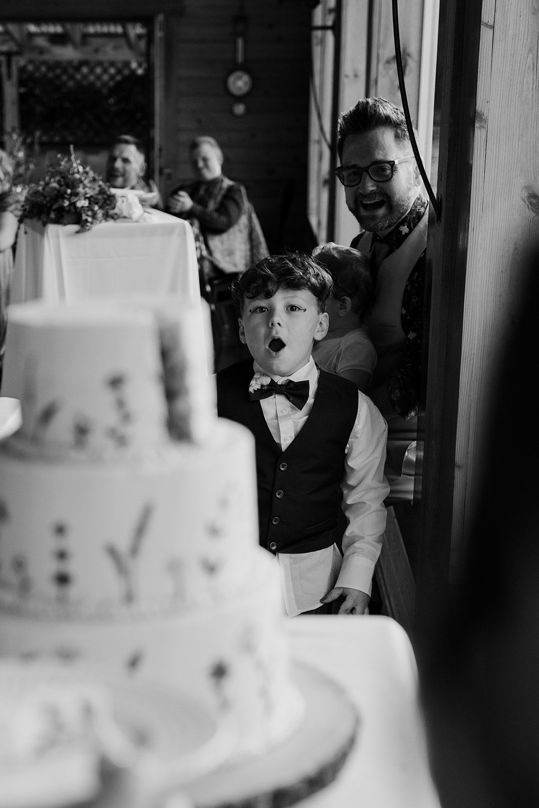 Black and white photo of a wedding cake display at a reception.