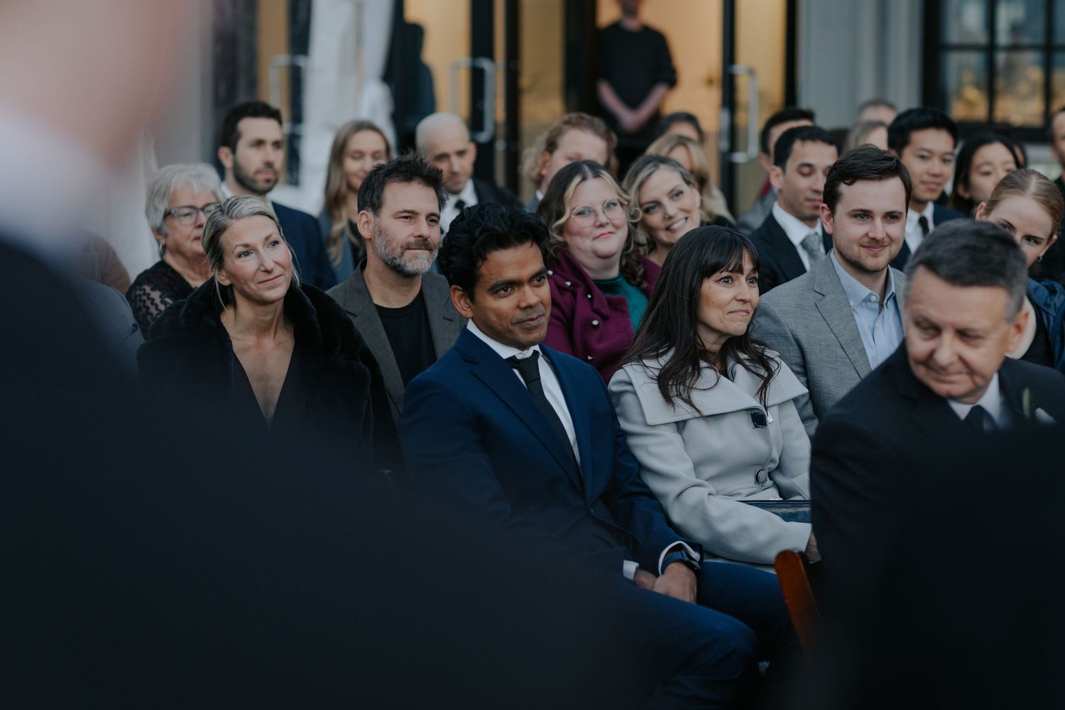 Wedding guests gather for outdoor celebrations against an urban backdrop.