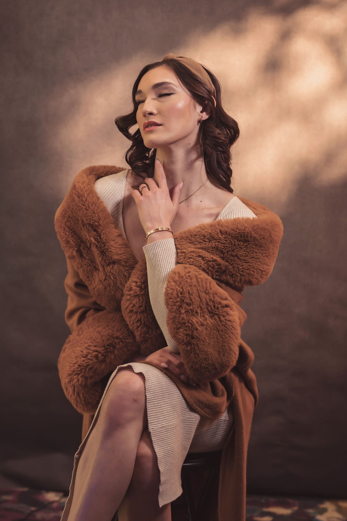 Fashion portrait featuring luxurious brown fur coat in warm lighting conditions.