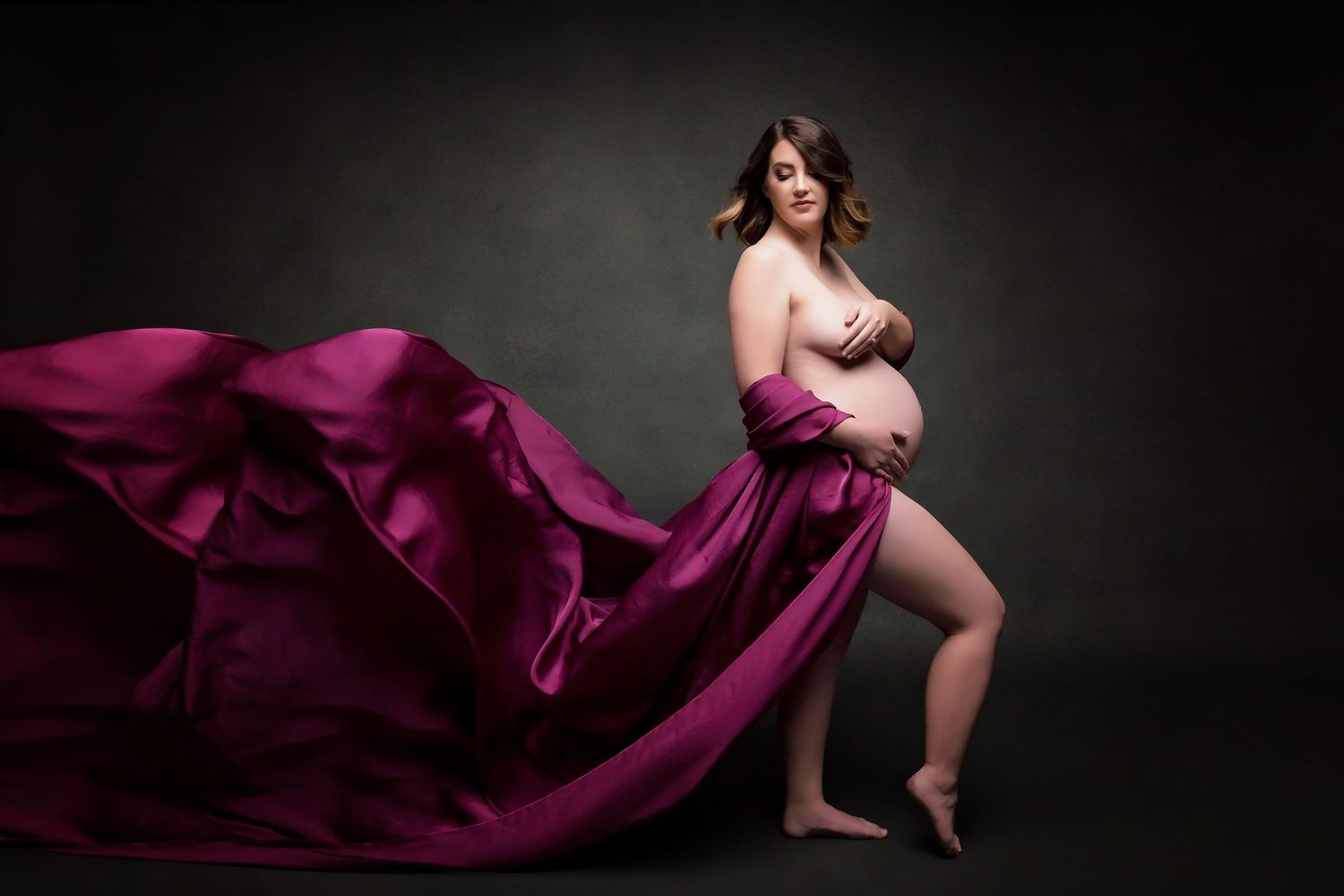 Rippling burgundy fabric creates dramatic movement in silhouette photography.
