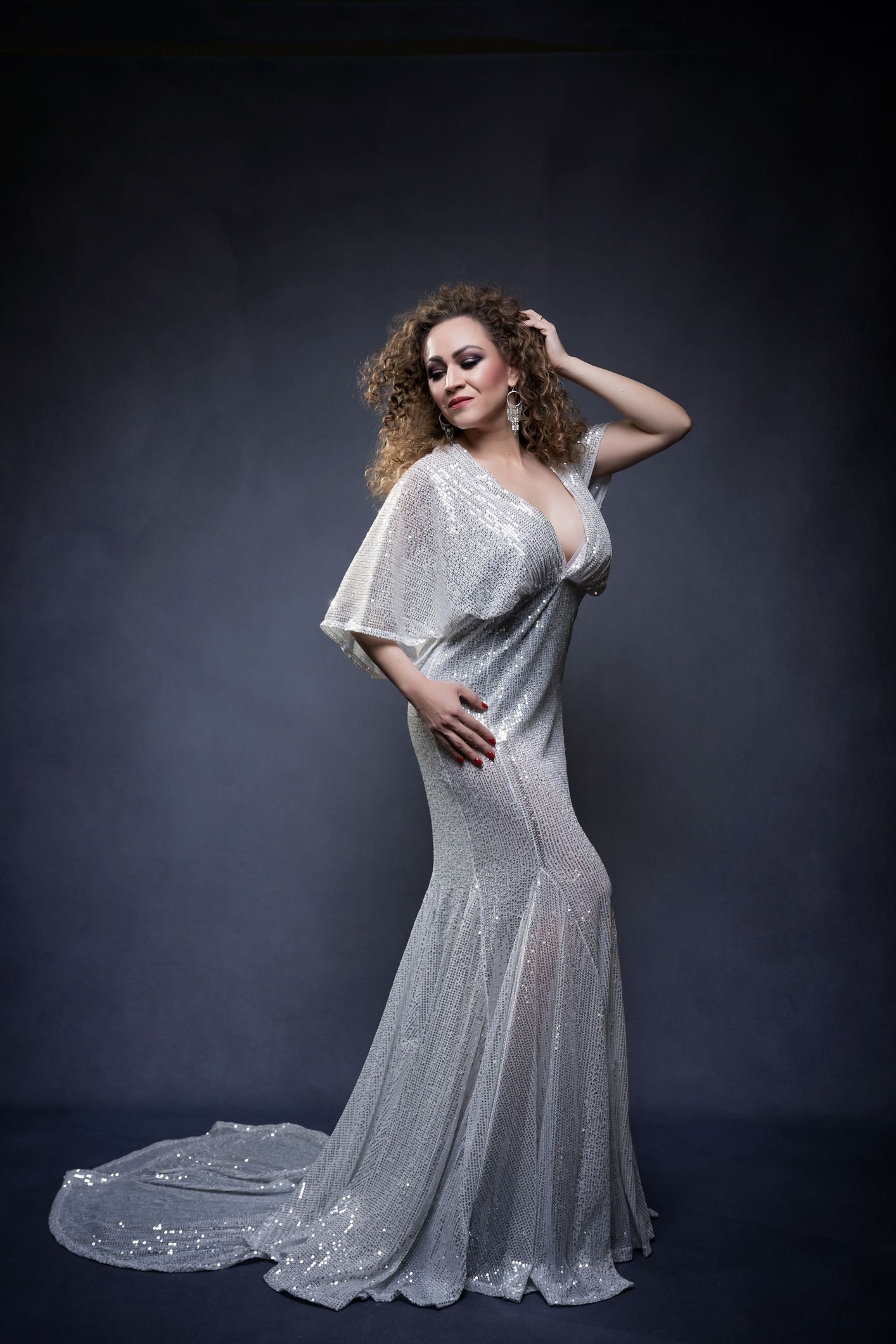 Shimmering silver evening gown captured in multiple artistic poses during a studio session.