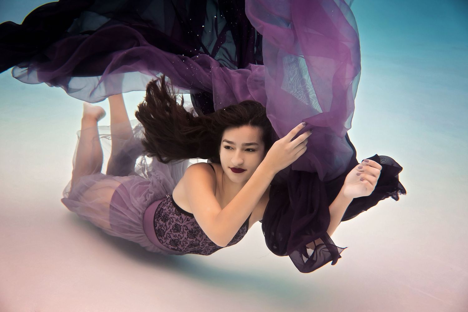 Ethereal figure in flowing purple dress floating gracefully against gradient sky background.