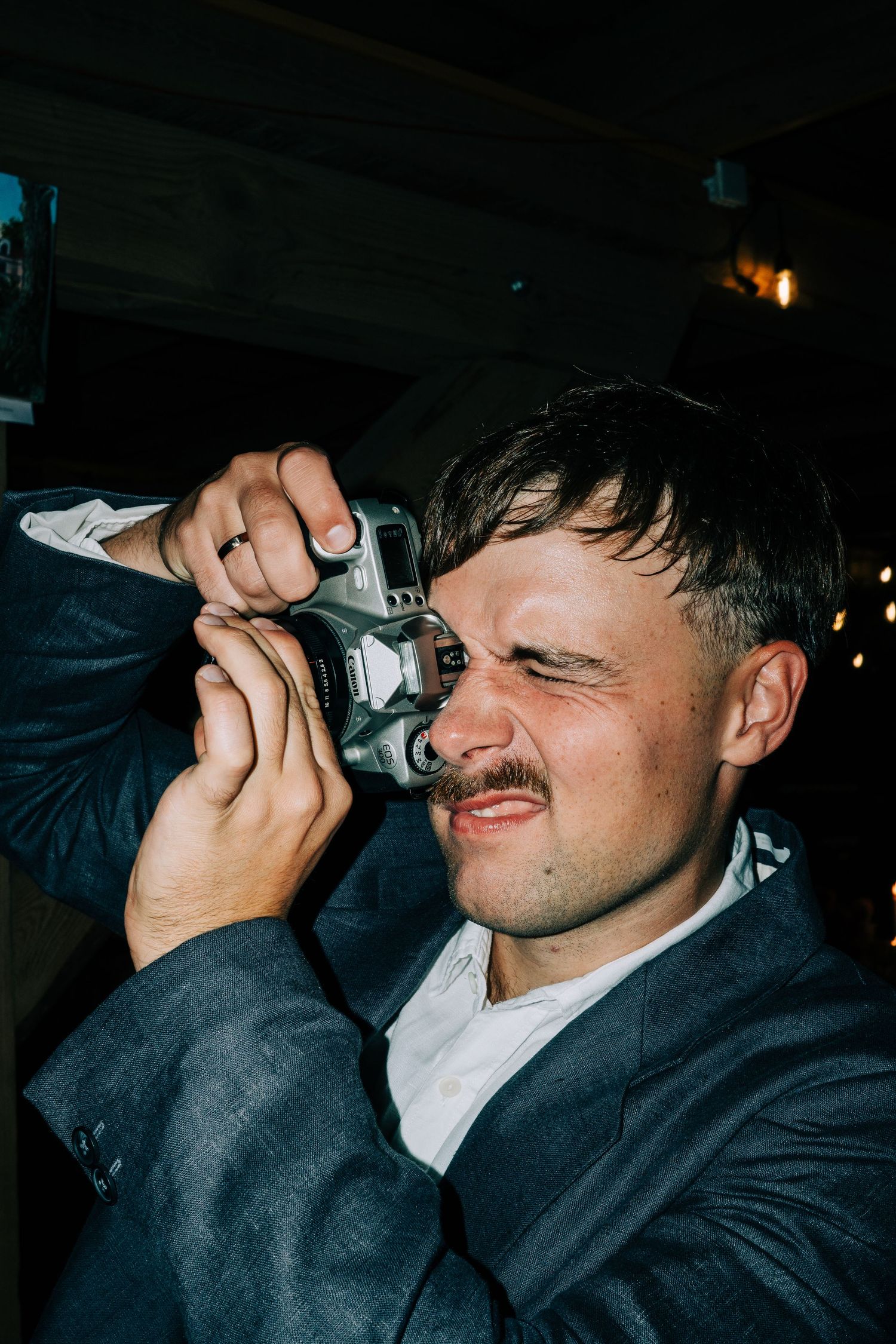 Party guest taking shots at a dimly lit nighttime celebration.
