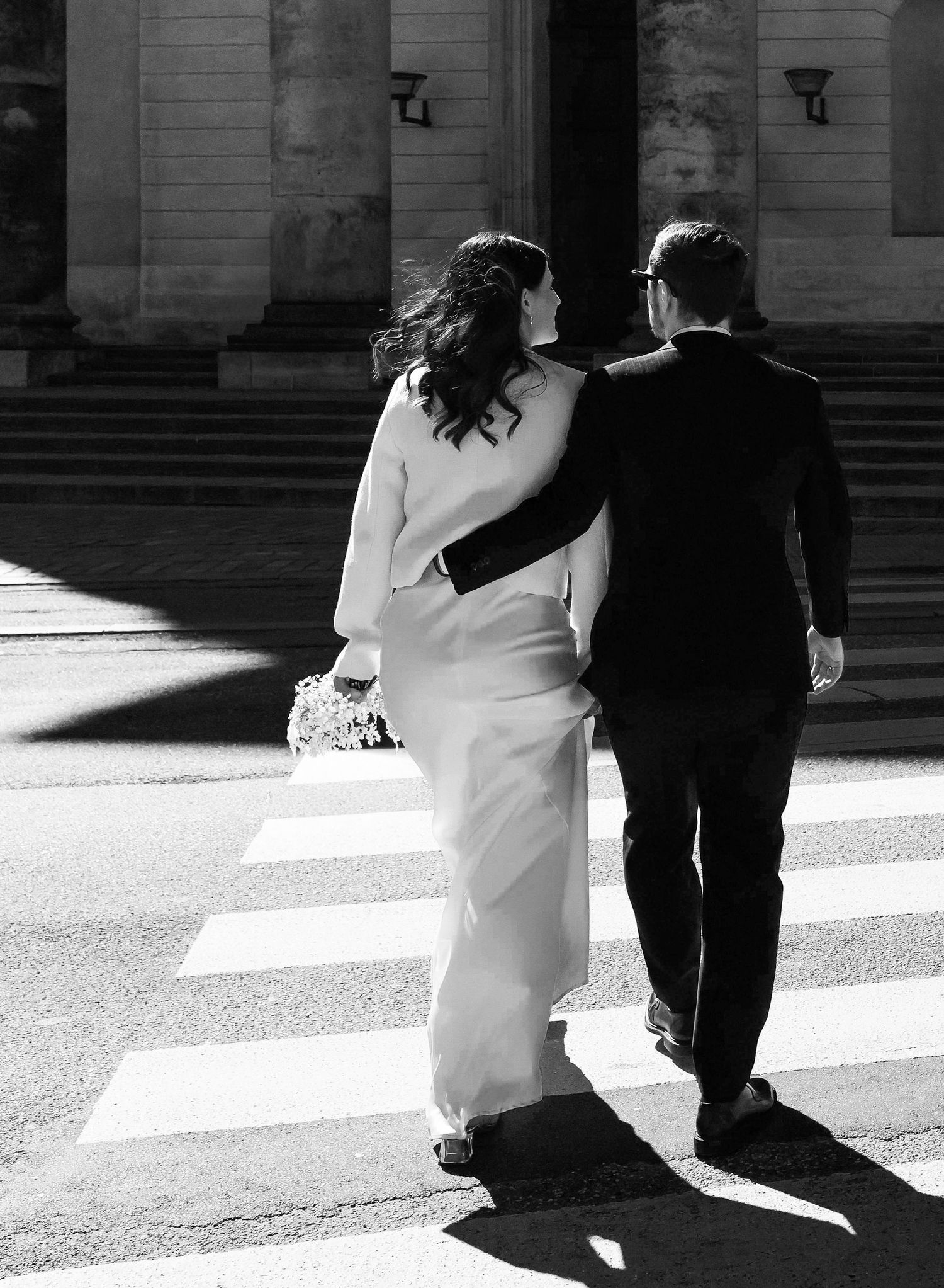 A black and white artistic wedding photo series showing couples walking together in formal attire.