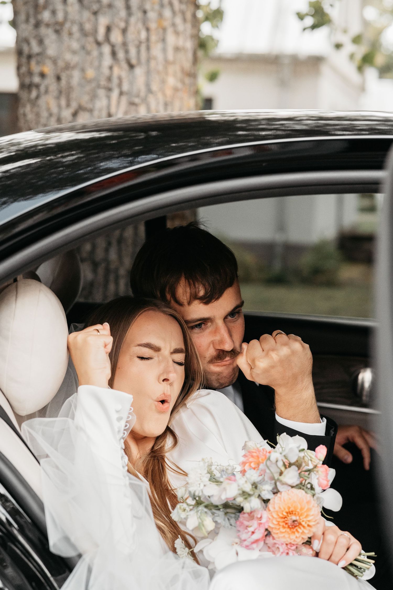 Tender romantic moment shared in a car with a beautiful floral bouquet.