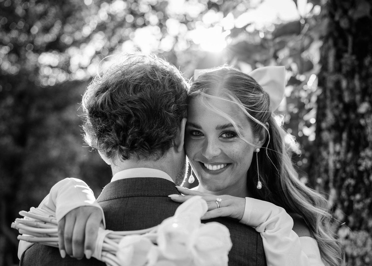 A black and white collage of intimate wedding moments showing couples embracing and sharing joyful moments outdoors.