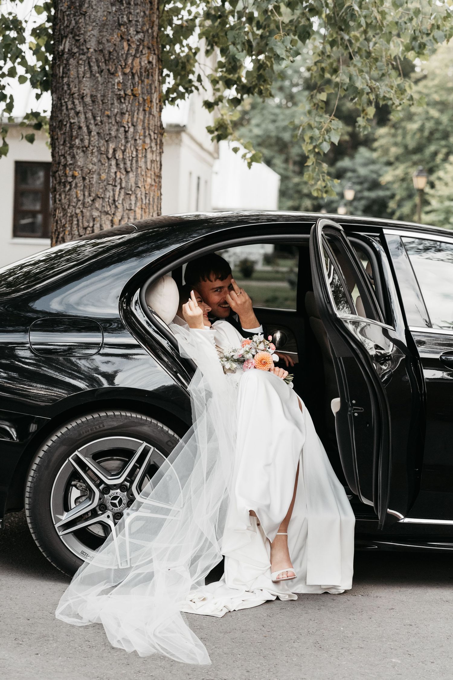 A romantic wedding photo series showing a couple in white attire near a black luxury car, with flowing veil details.