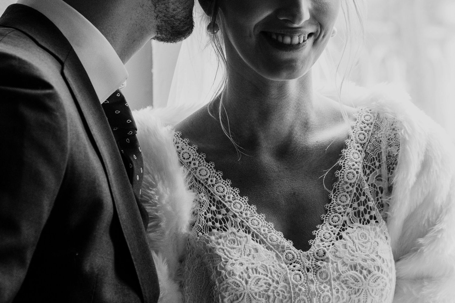 Black and white wedding photos showing close-up details of bride's lace dress and romantic moments.