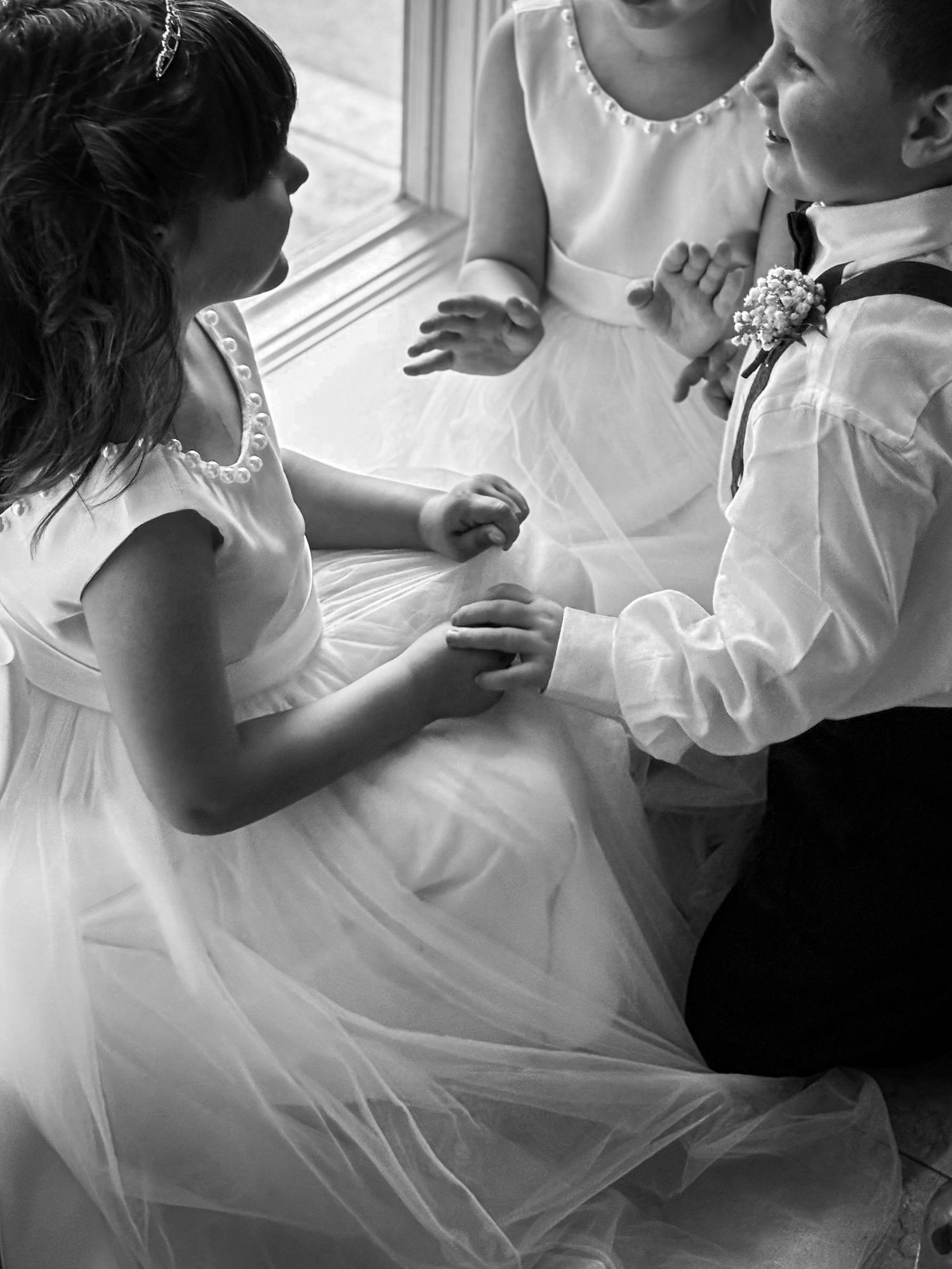 A series of black and white wedding photos showing tender moments between a couple in white attire.