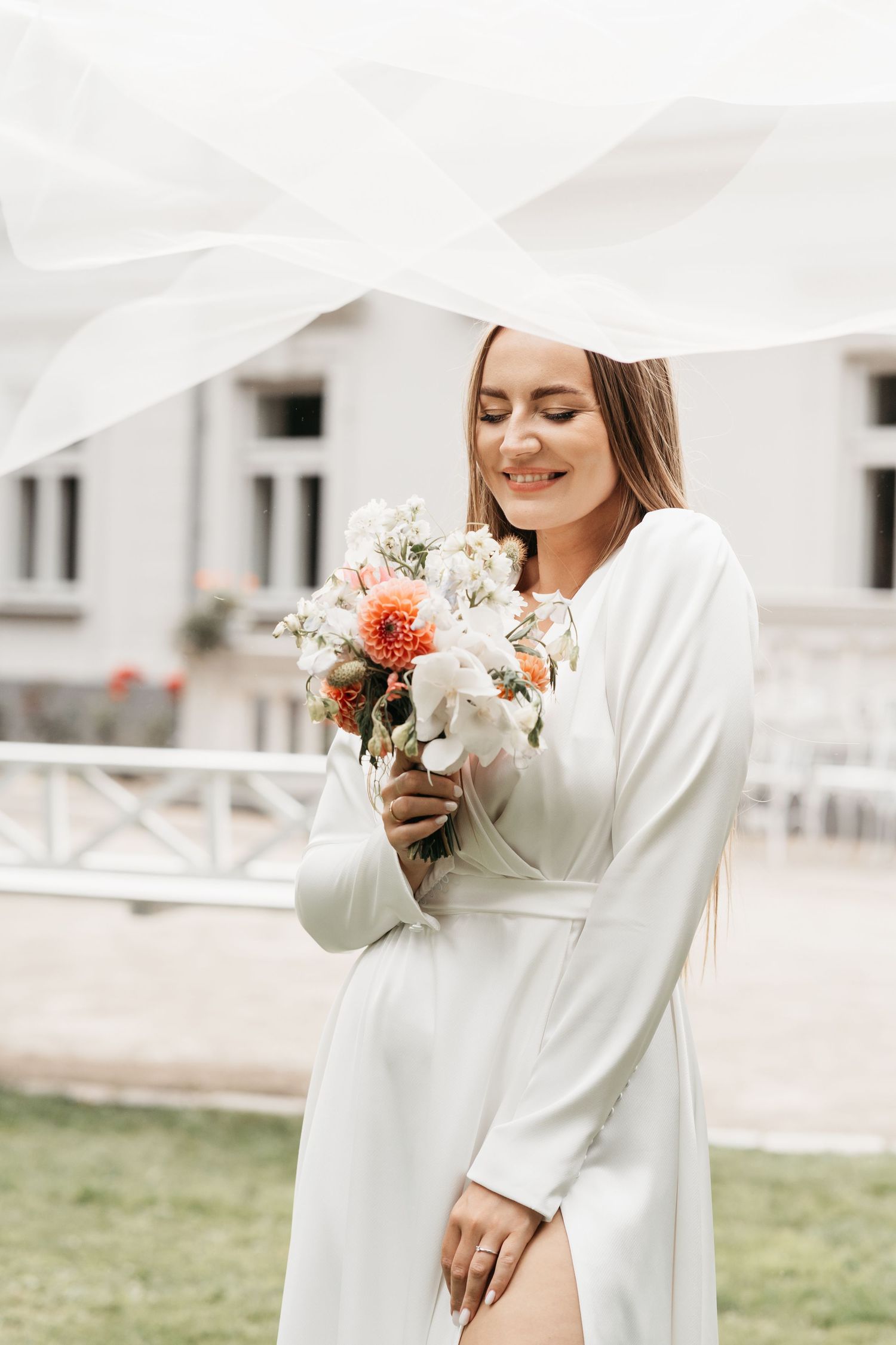 Elegantly dressed in white with delicate flowers creating a romantic outdoor bridal portrait series.