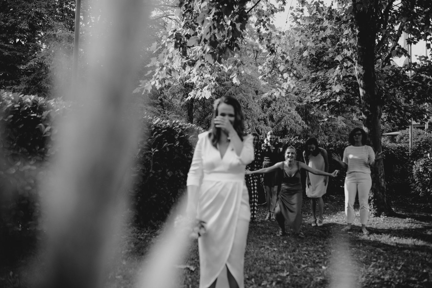Black and white candid shot of celebration in an outdoor garden setting.