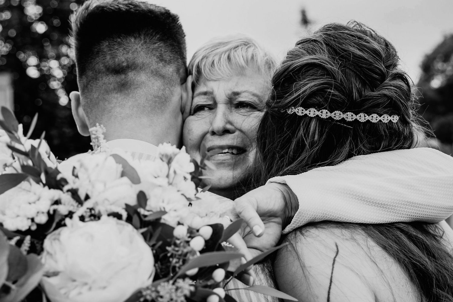 Black and white photos showing tender moments of people embracing and hugging each other at various occasions.