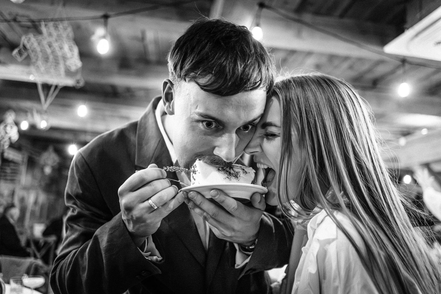 Black and white wedding photos show intimate moments between newlyweds dancing and embracing at their reception.