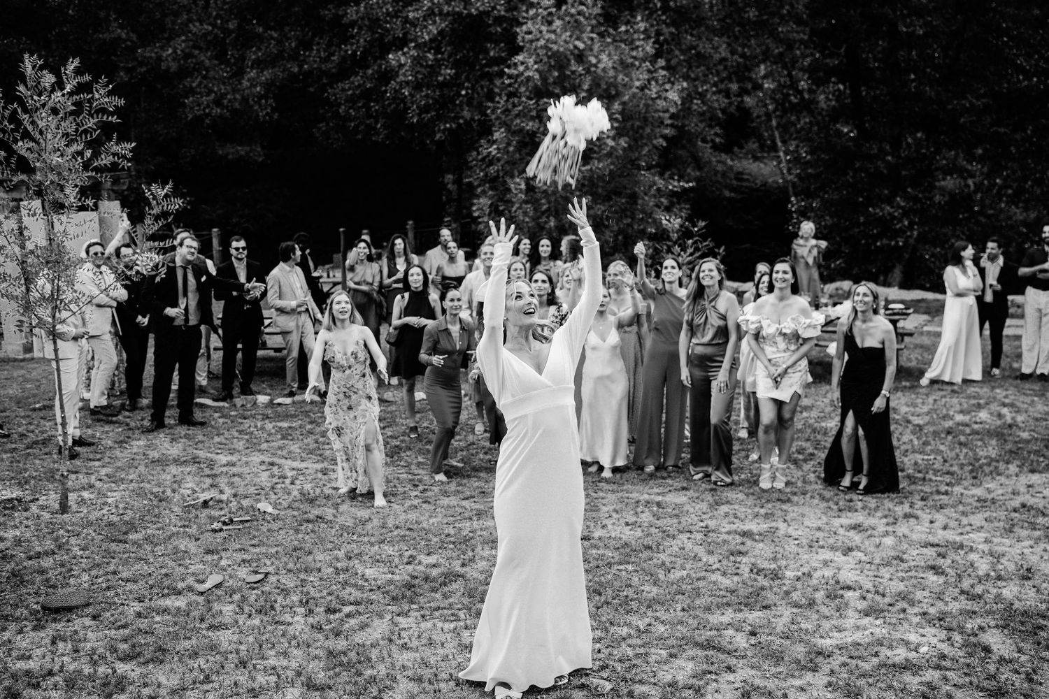 A joyful outdoor wedding ceremony with guests watching as the couple celebrates in a garden setting.