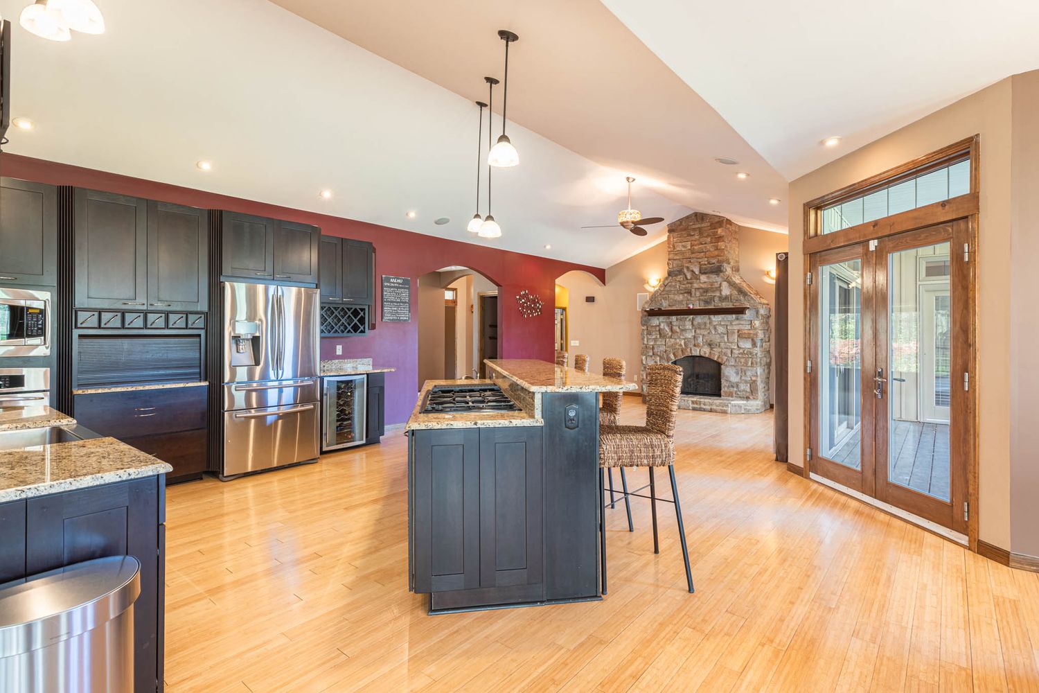 Modern open concept home interior with hardwood floors, recessed lighting, and navy blue accent walls.