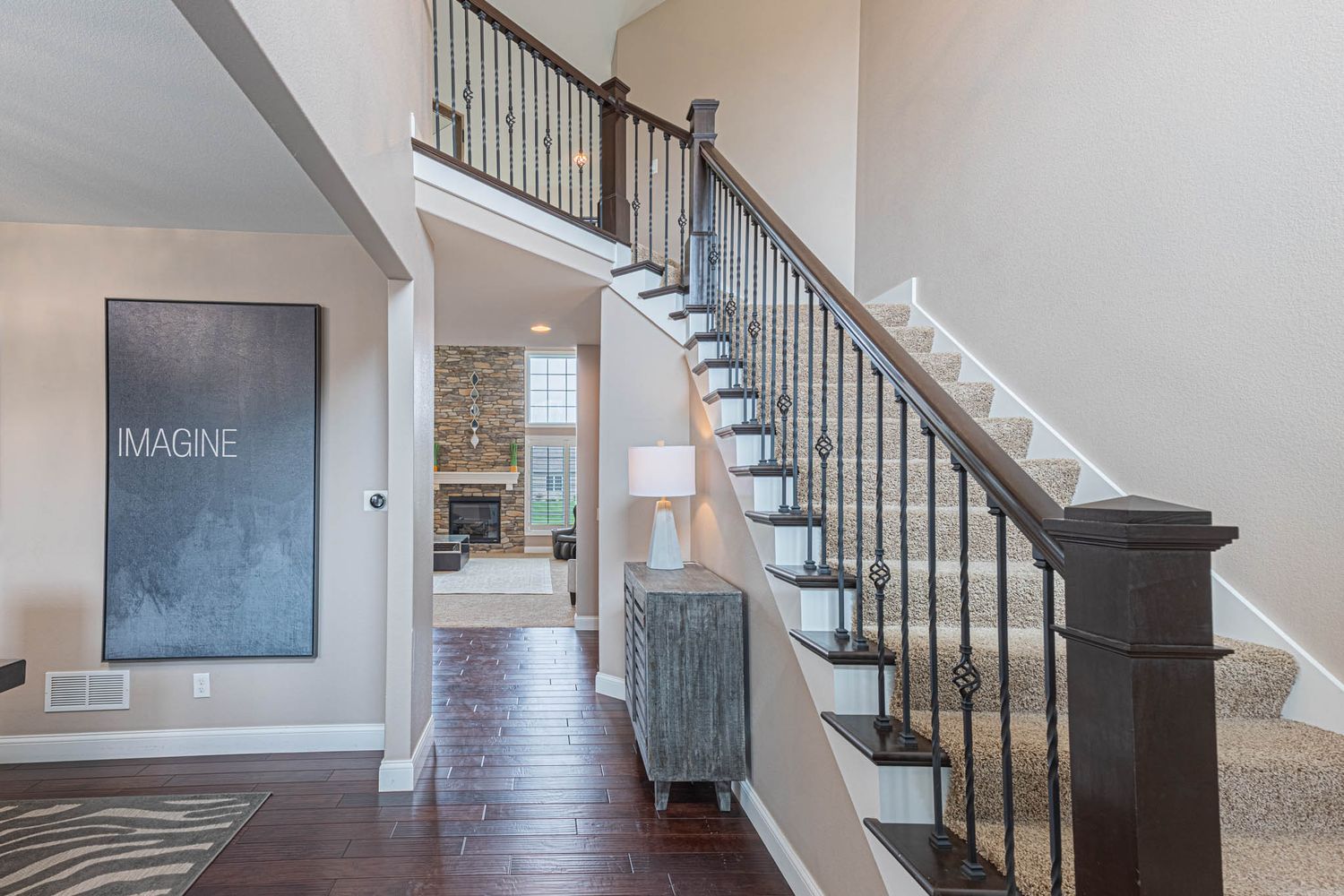 Modern staircase with dark wood handrails, white risers, and a chalkboard wall accent in an elegant foyer.