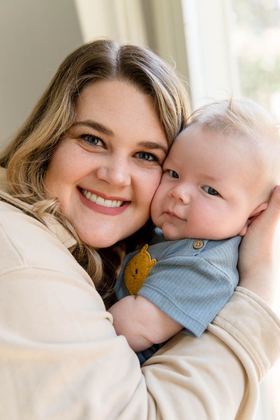 A tender moment between parent and baby as they share a warm embrace and smile together.