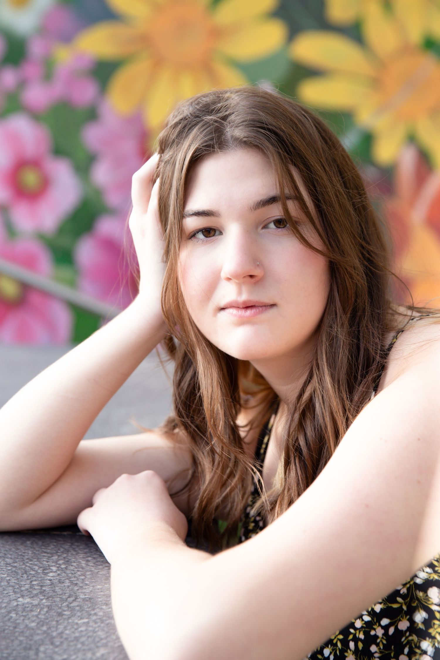 Portrait against floral backdrop with soft lighting and natural pose.