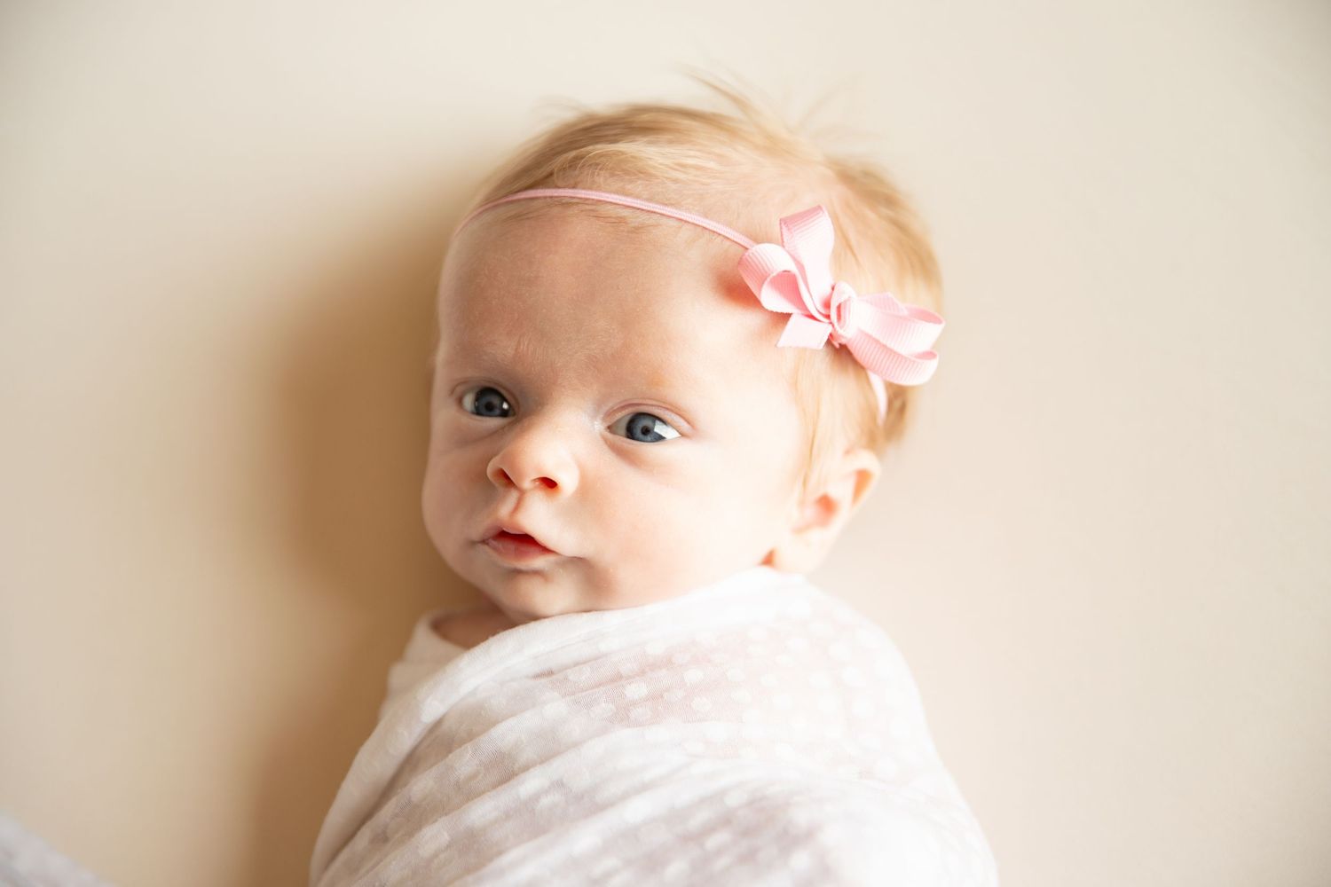 Series of gentle newborn portraits with soft lighting against cream background.