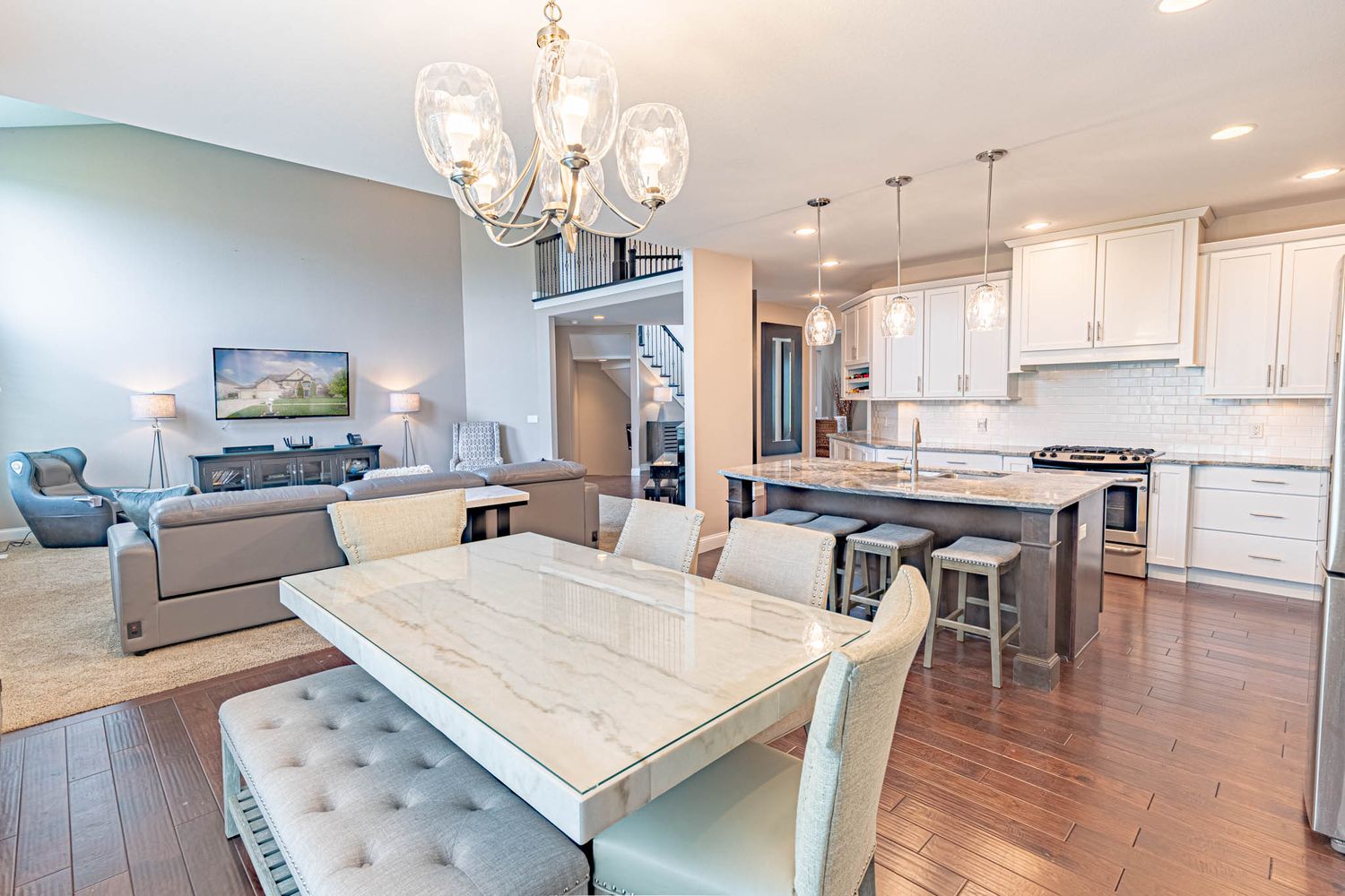 Elegant dining area with crystal chandelier and open concept layout connecting to kitchen.