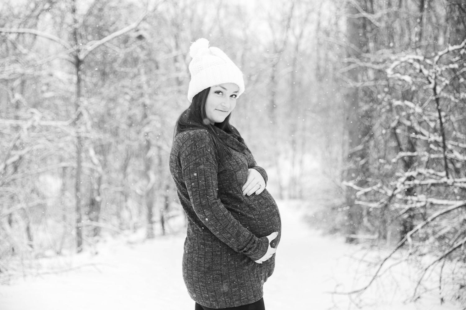 Winter maternity photos captured in a snow-covered forest landscape.