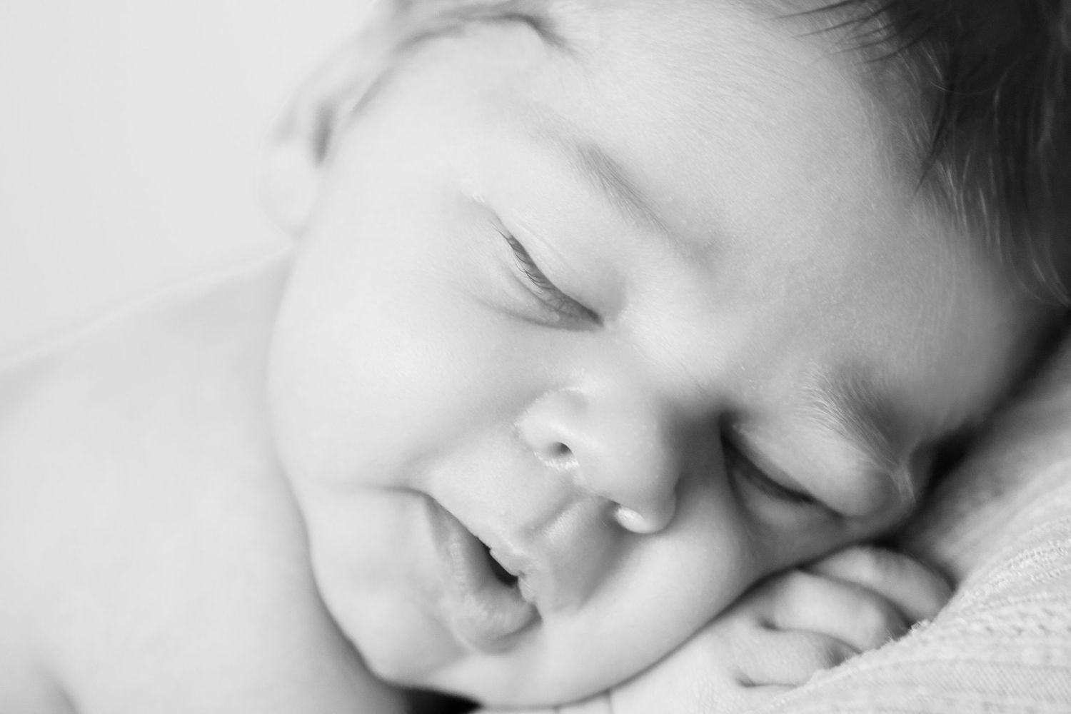 Close-up black and white portrait of sleeping baby with peaceful expression.