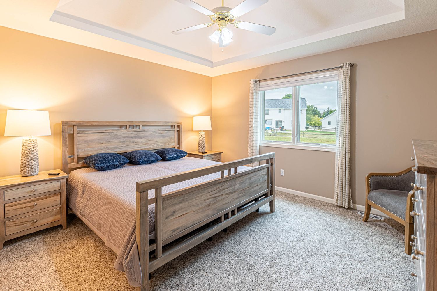 Master bedroom with vaulted ceiling, ceiling fan, and neutral carpeting.