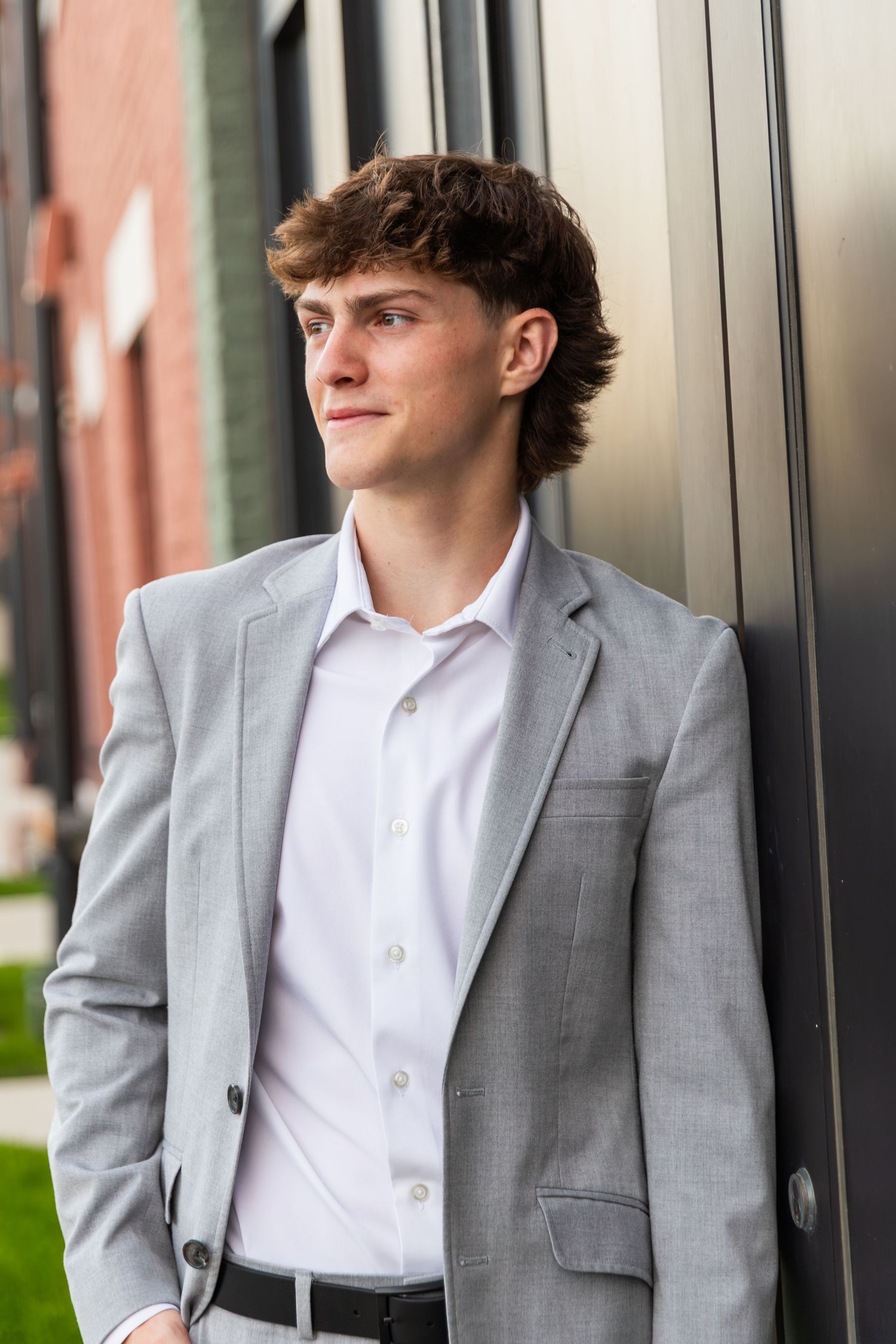 Professional portrait of person in light gray suit jacket looking to the side.