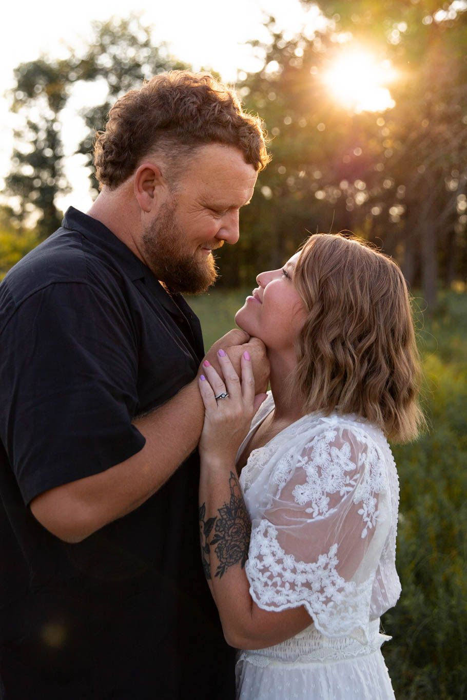 Intimate wedding couple shares romantic moment at sunset in a garden setting.