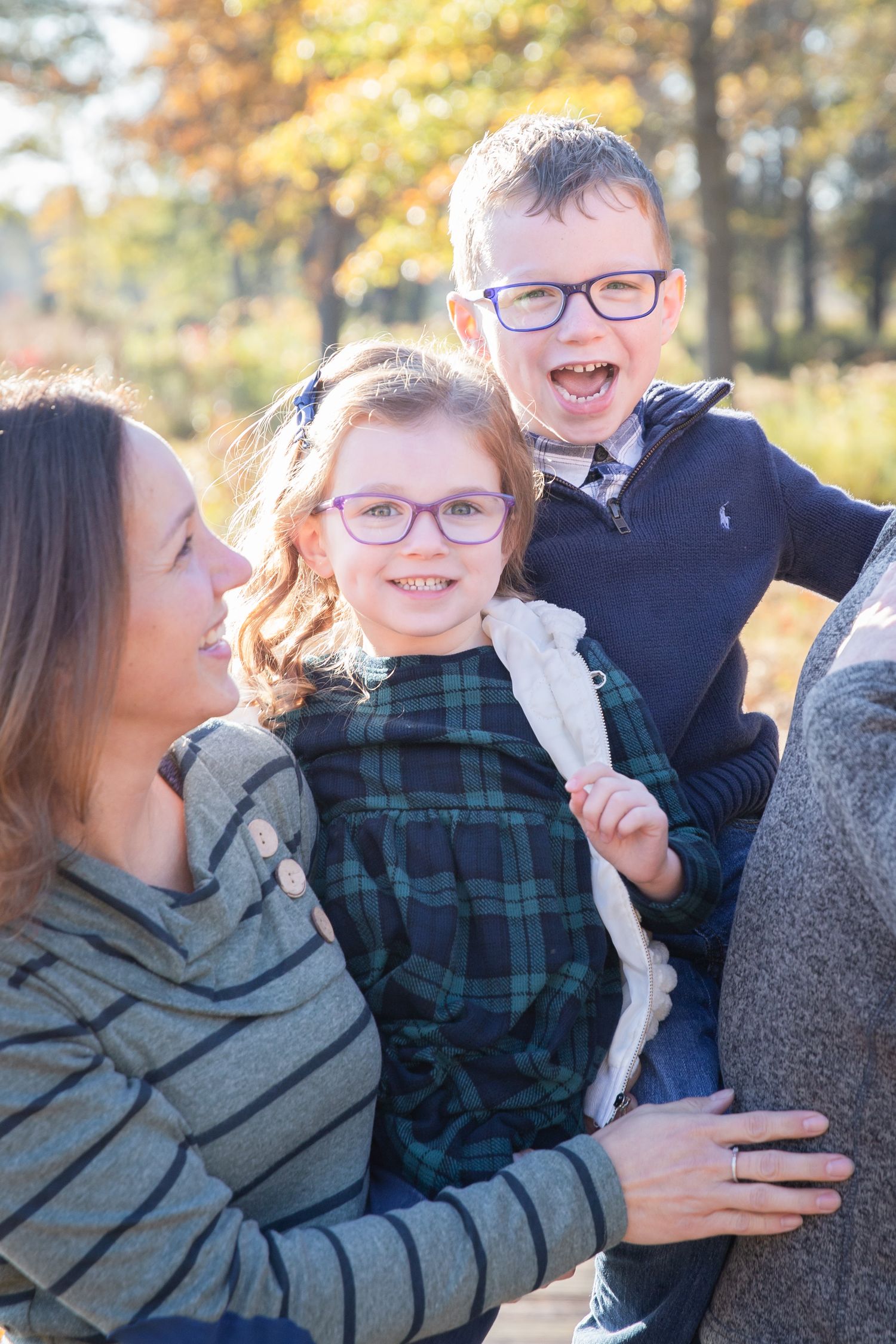 Candid family portrait showing joyful interactions during autumn outdoor photo session.