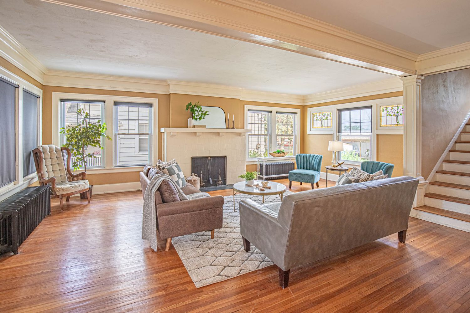 Spacious open concept living room with hardwood floors and large windows providing natural light.