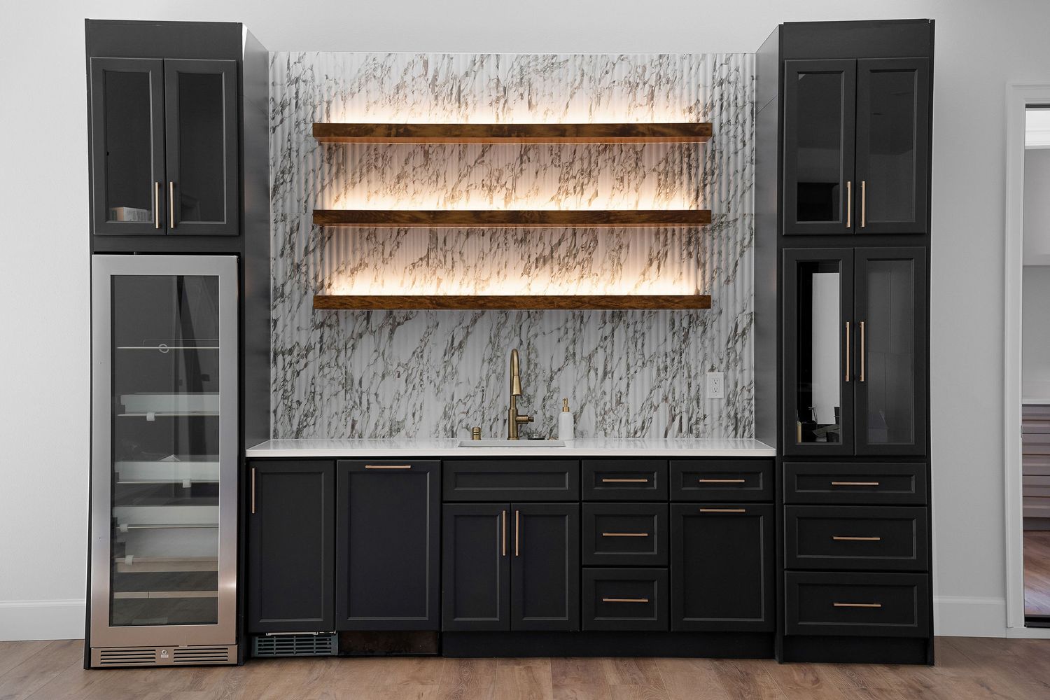 Modern black built-in cabinetry with floating wood shelves and a textured gray wallpaper backdrop.
