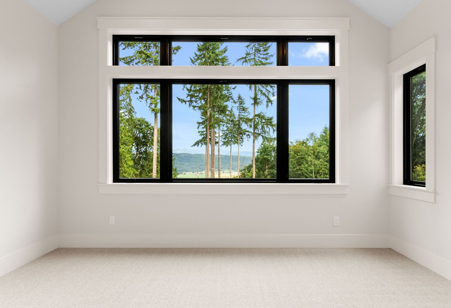 Minimalist room with high ceilings and clerestory windows bringing in natural light.
