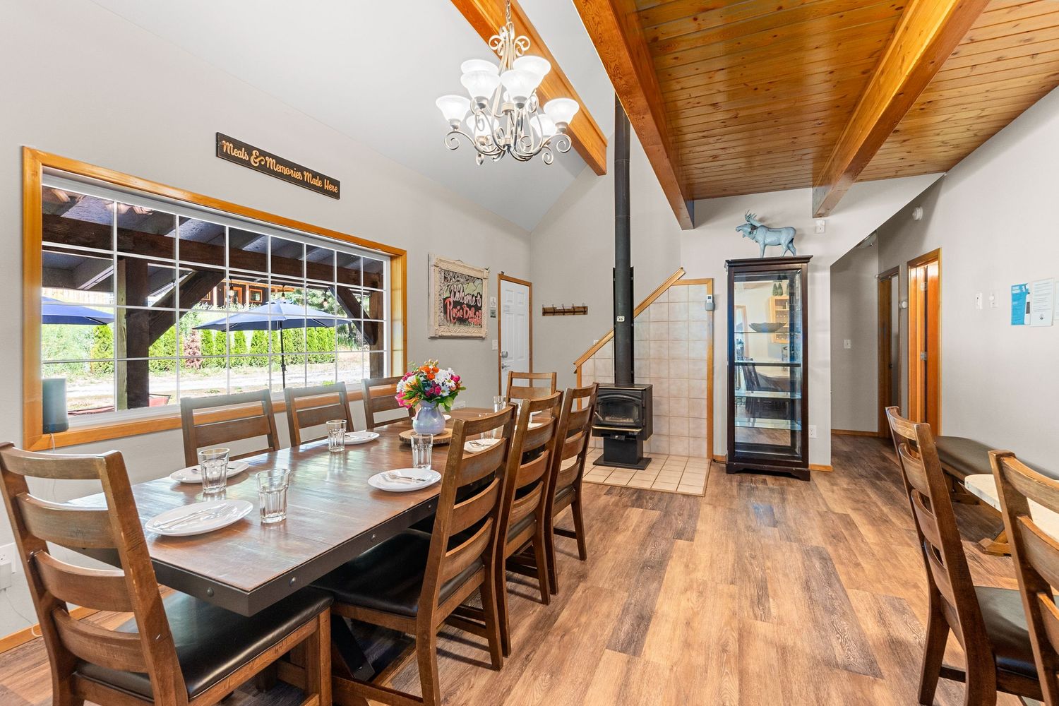 Rustic dining area with wooden beams and tables arranged in a long hall-like setting.
