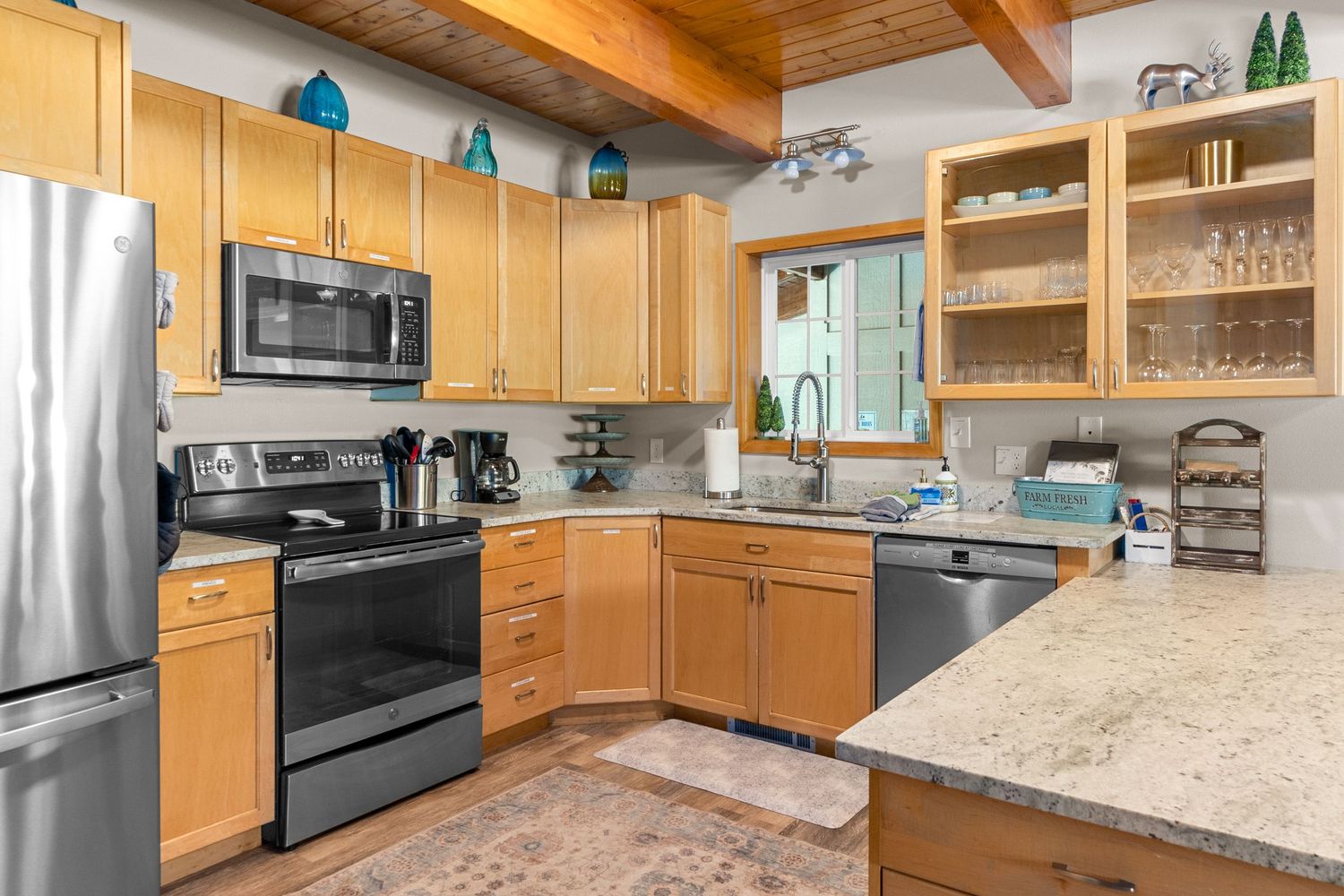 Spacious modern kitchen with wood cabinets, granite countertops and stainless steel appliances.