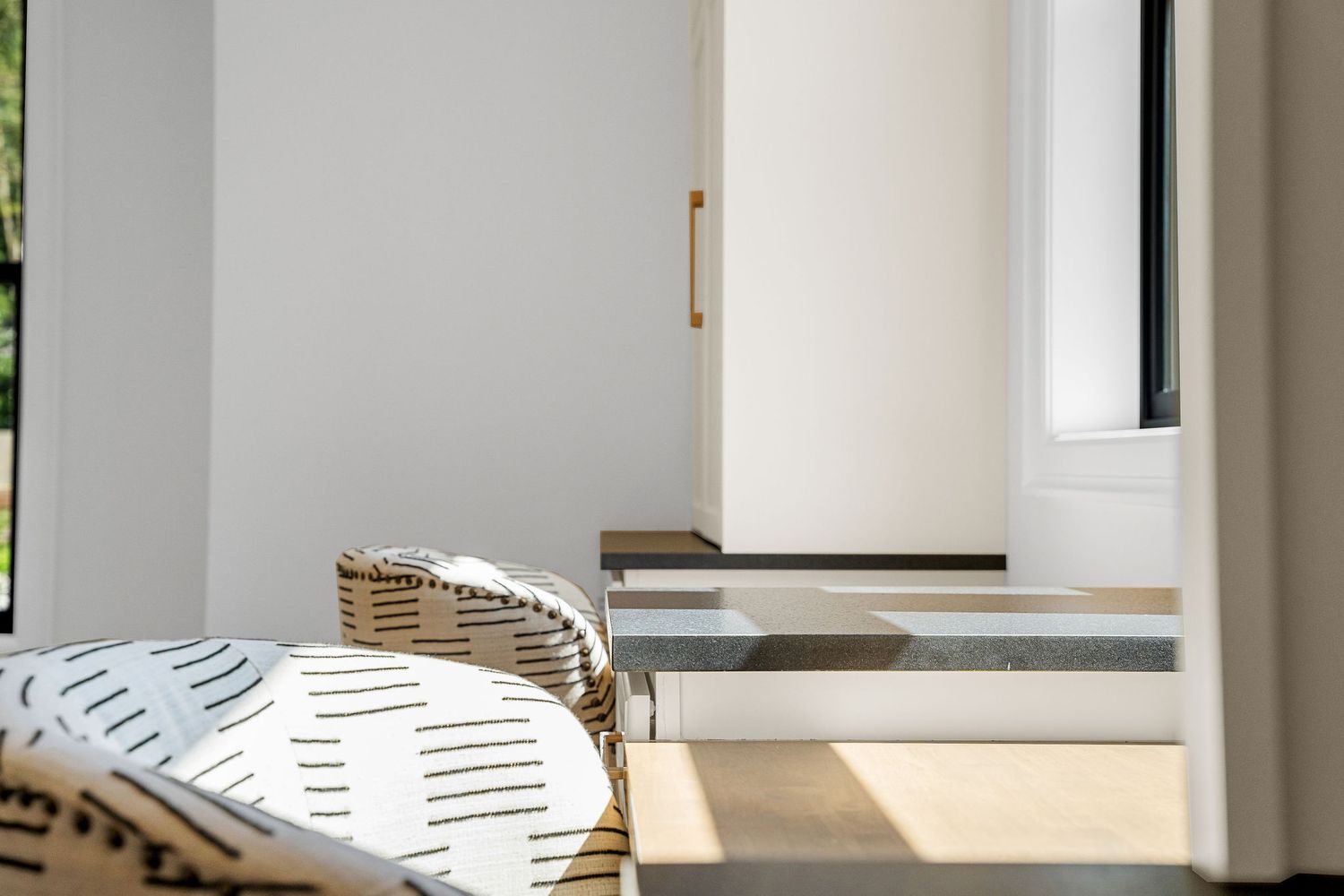 Sunlit entryway with patterned cushion and steps leading to interior door.