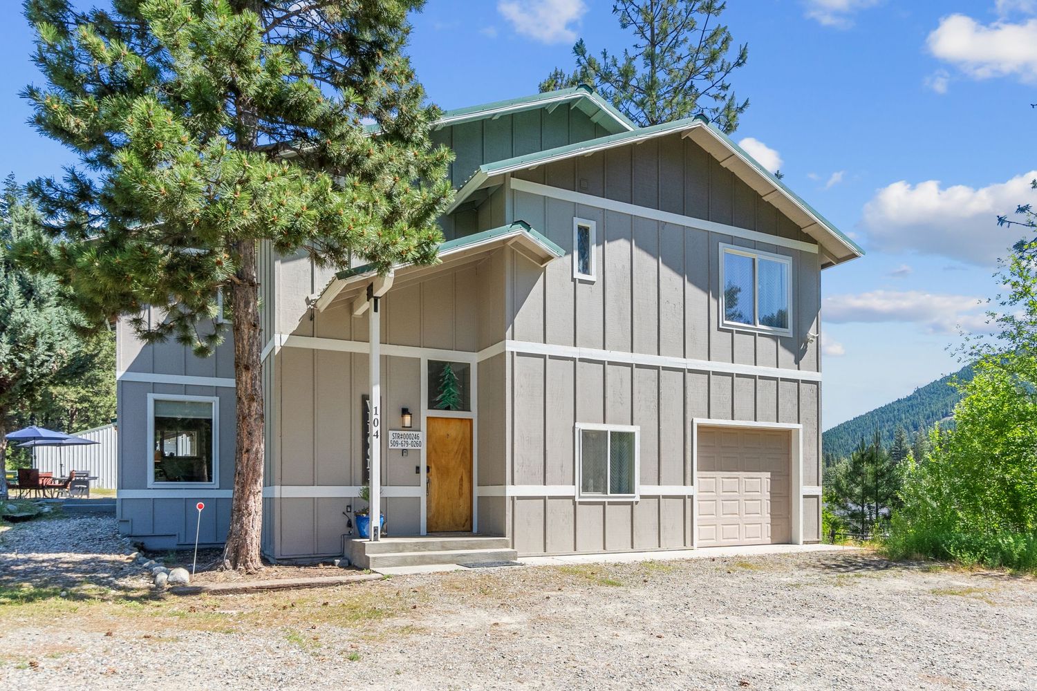 Row of modern gray townhouses with garages on a hillside property.