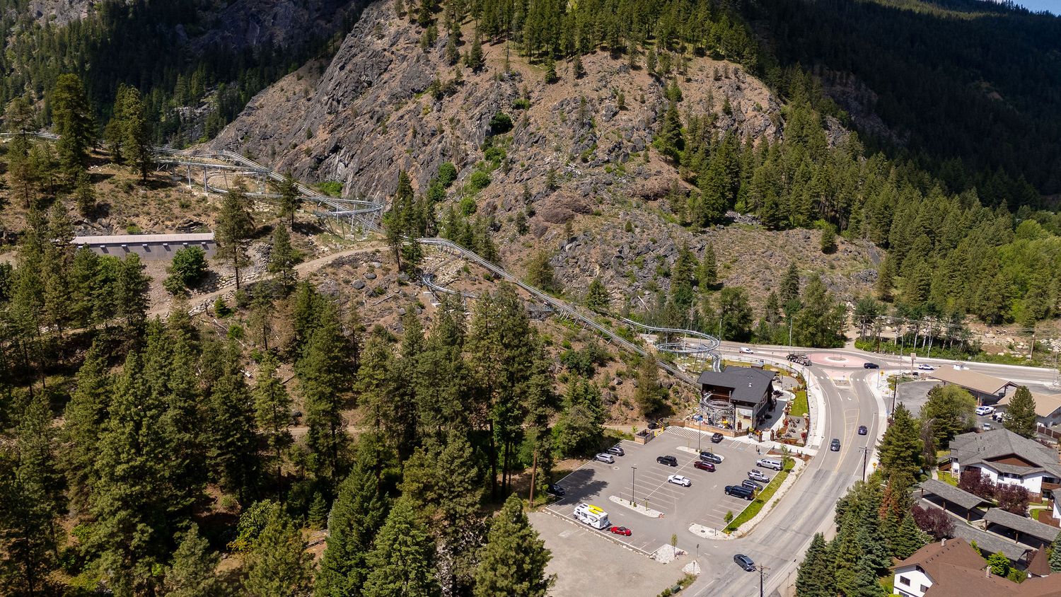 Aerial panoramic view of a winding mountain road through scenic Hells Canyon in Idaho with evergreen trees.