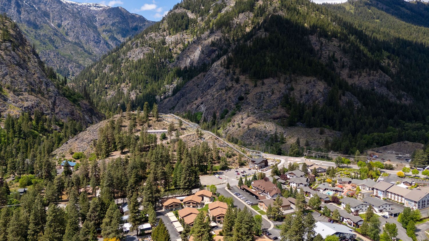 Dramatic mountain gorge with steep cliffs and small town nestled in valley below.