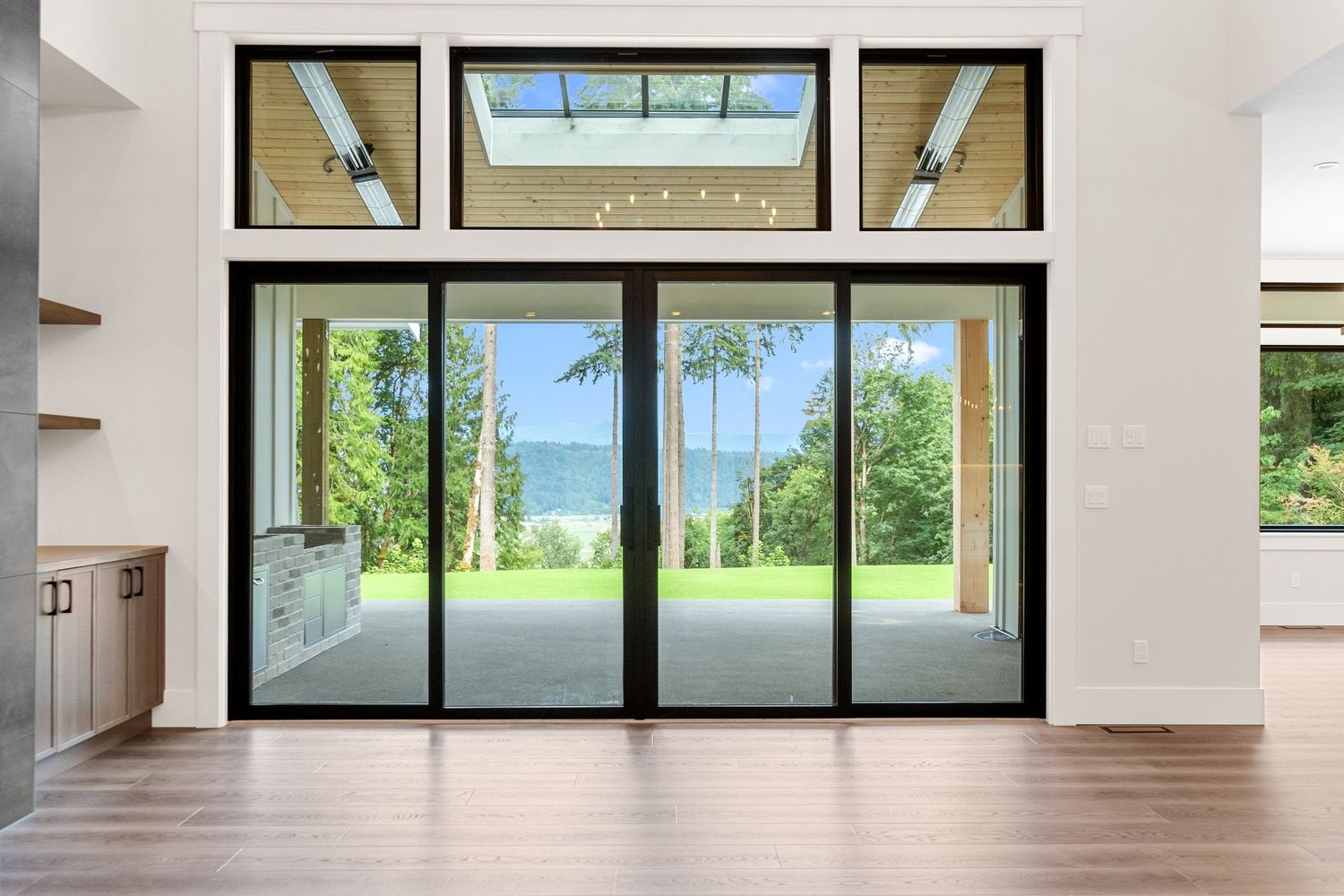 Modern living space with floor-to-ceiling sliding glass doors and transom windows above.