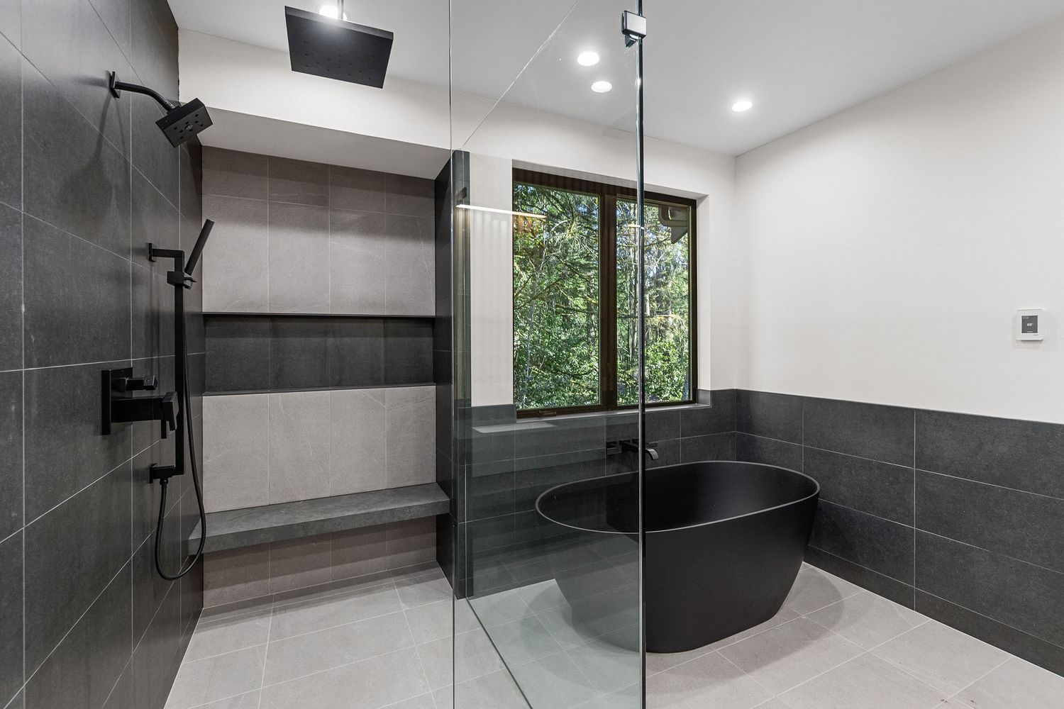 Luxurious bathroom interior with black tile accents and glass shower enclosure showcasing modern design elements.