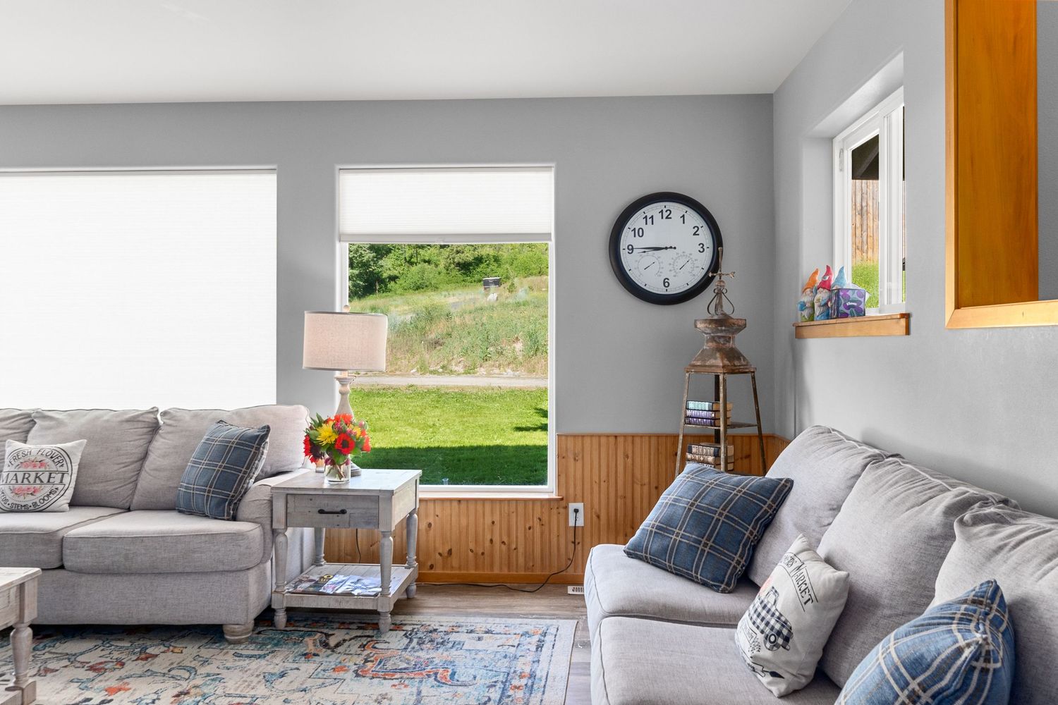 Contemporary living room with vaulted ceilings, gray furniture and large windows.