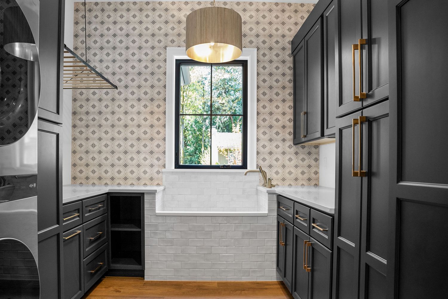 Butler's pantry with patterned wallpaper, dark cabinets, and brass hardware details.