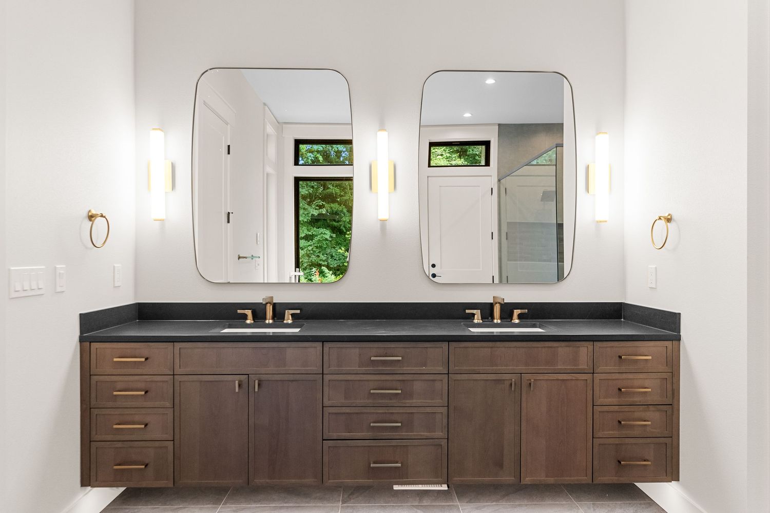 Contemporary double vanity bathroom with dark wood cabinets and rectangular mirrors.