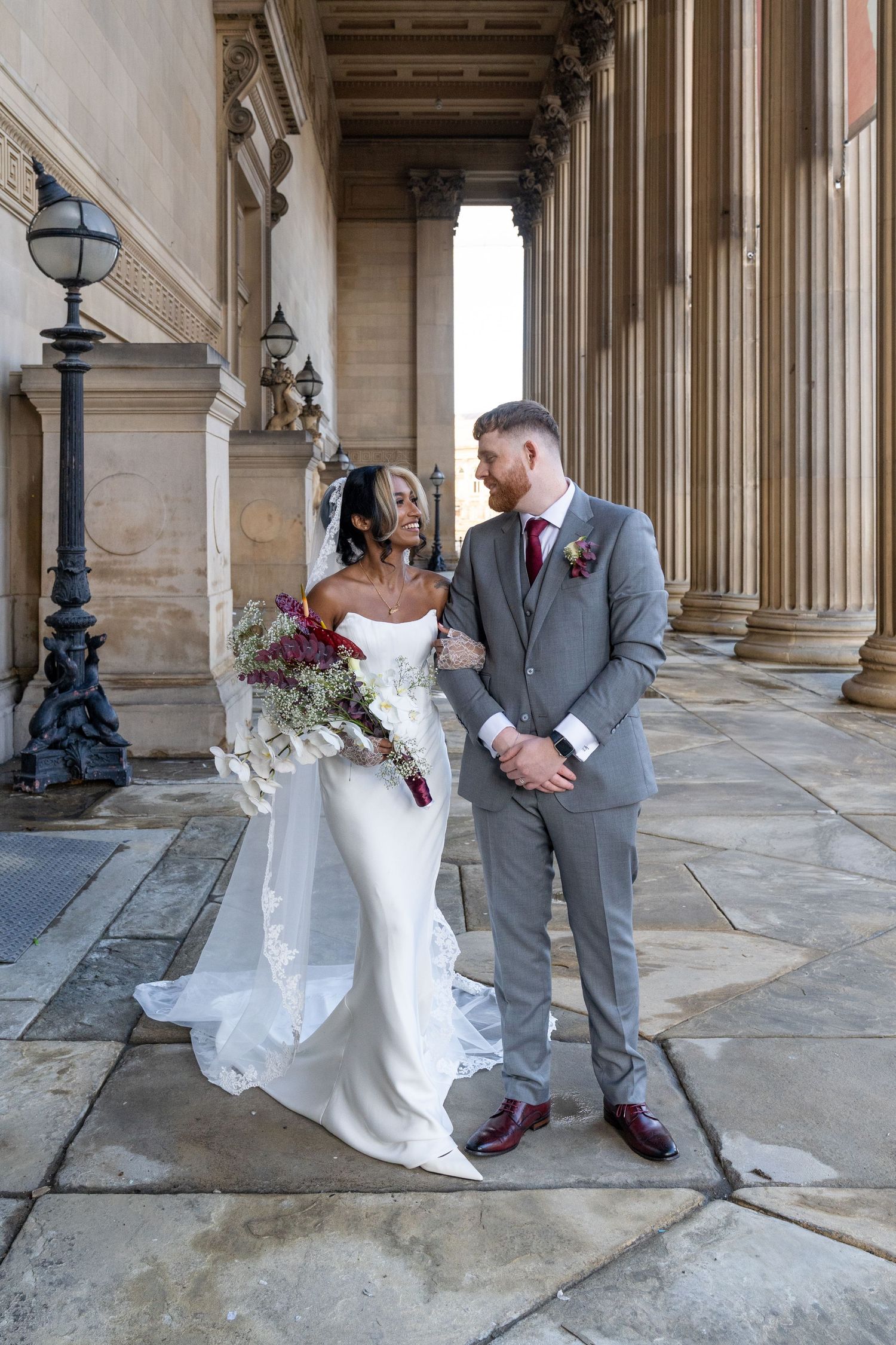 Wedding couple shares playful moments in a sequence of romantic poses under an elegant columned portico.