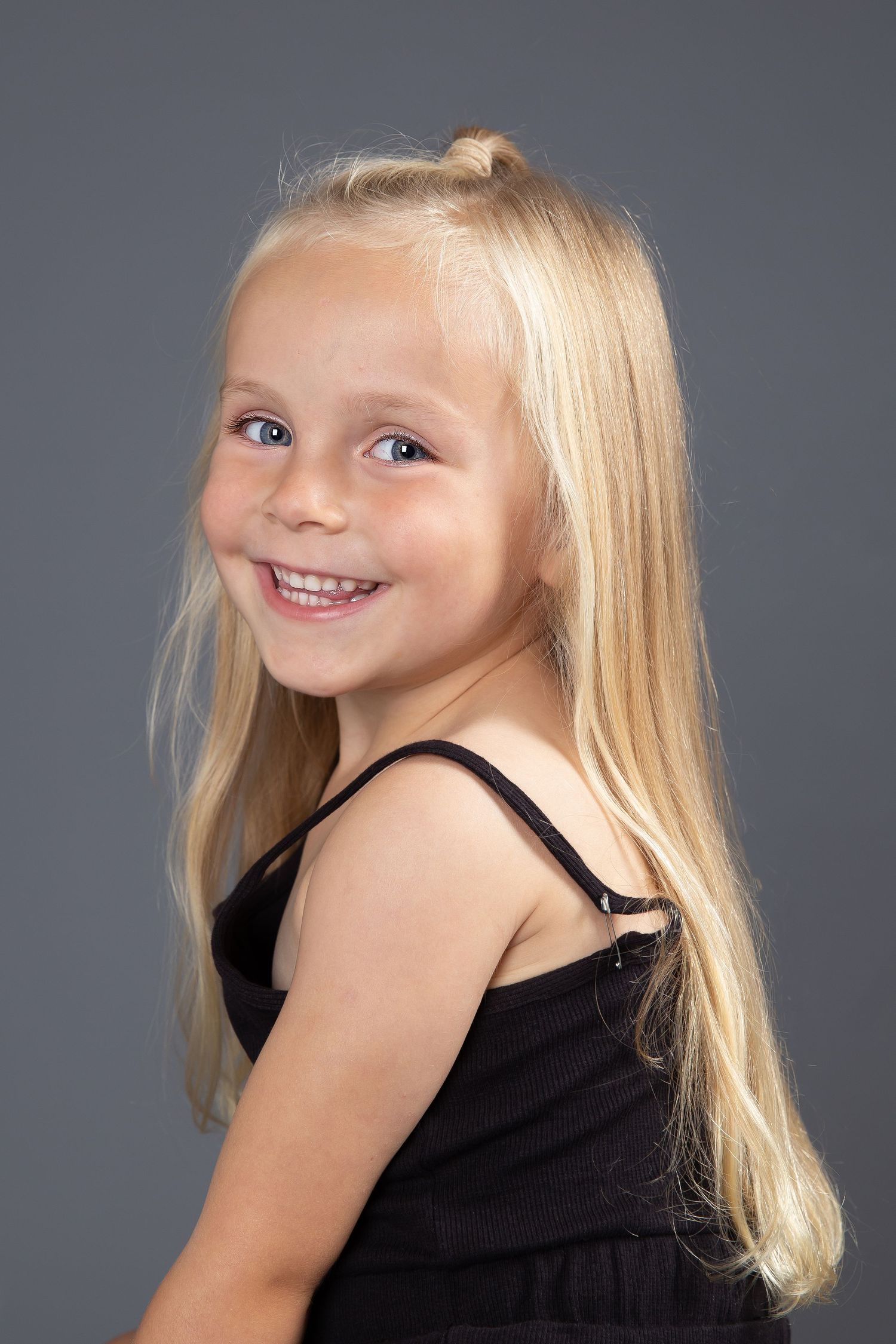 Series of profile studio portraits against a gray background showing shoulder-length blonde hair and black top.
