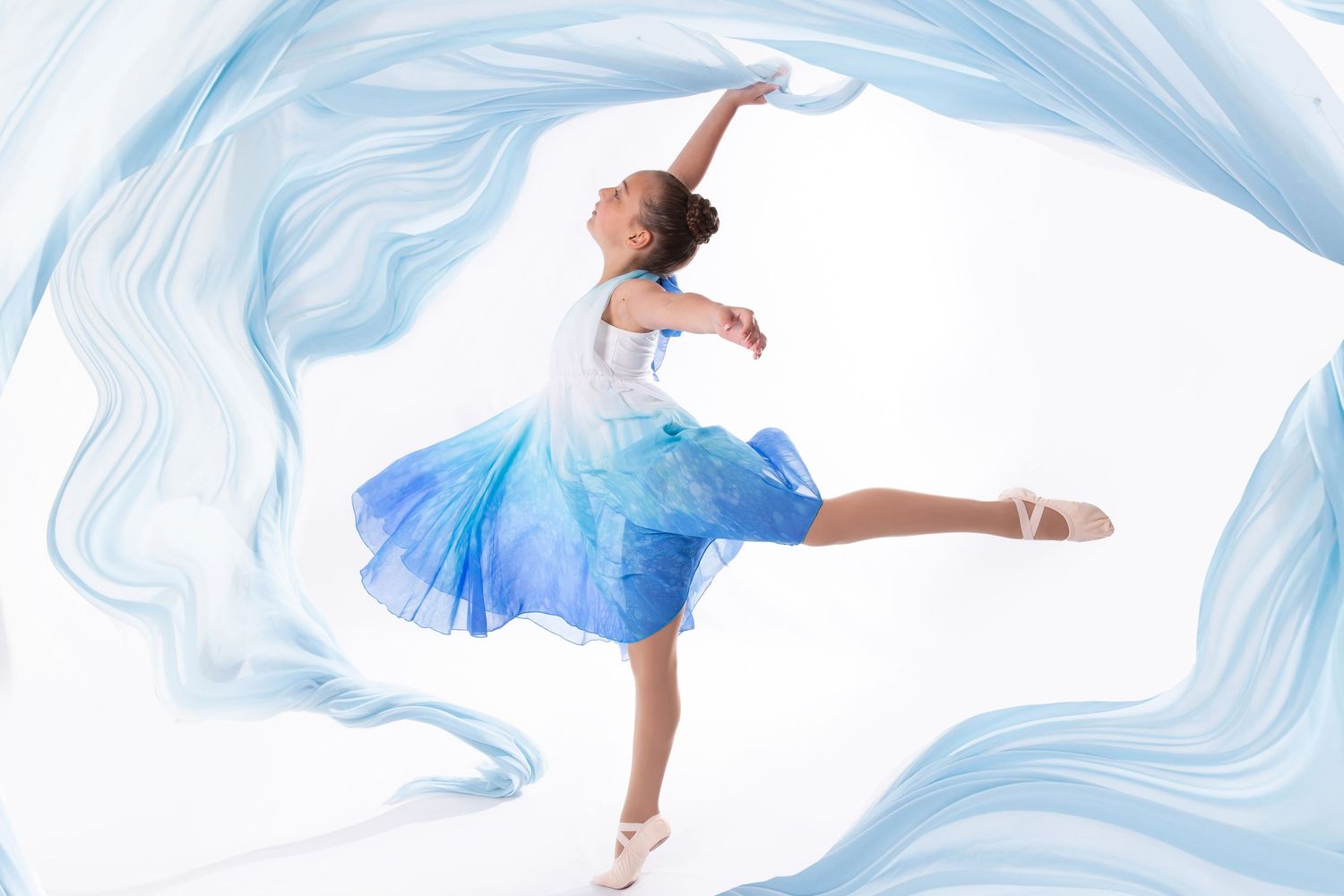 Graceful ballerinas in flowing blue dresses dance across a white marble background with swirling blue patterns.